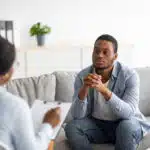 Psychological help service. Depressed male patient having psychotherapy session with counselor at mental health clinic